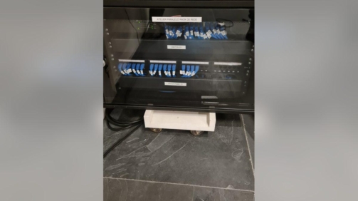 Rack de rede com patch panels identificados em escritório de arquitetura