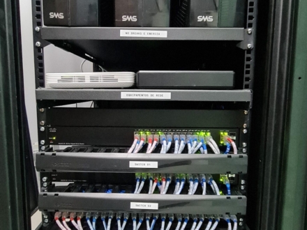 Rack de piso com nobreaks e patch panels em escritório de engenharia